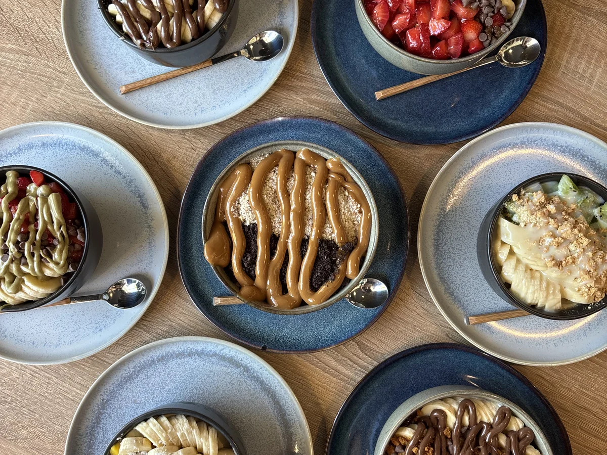 Siete bowls de açaí servidos sobre la mesa