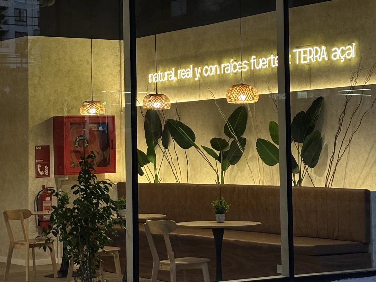 Vitrina de TERRA açaí de noche, con el letrero de neón encendido